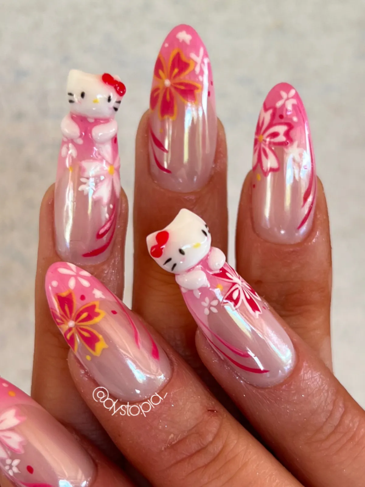 Rožnati nohti s 3D Hello Kitty figuricami in češnjevimi cvetovi