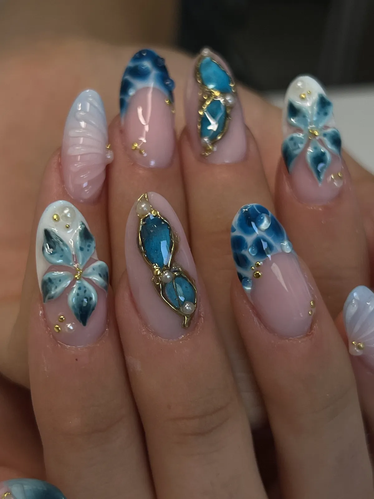 Nohti z modrimi dragulji v zlati obrobi in 3D cvetovi